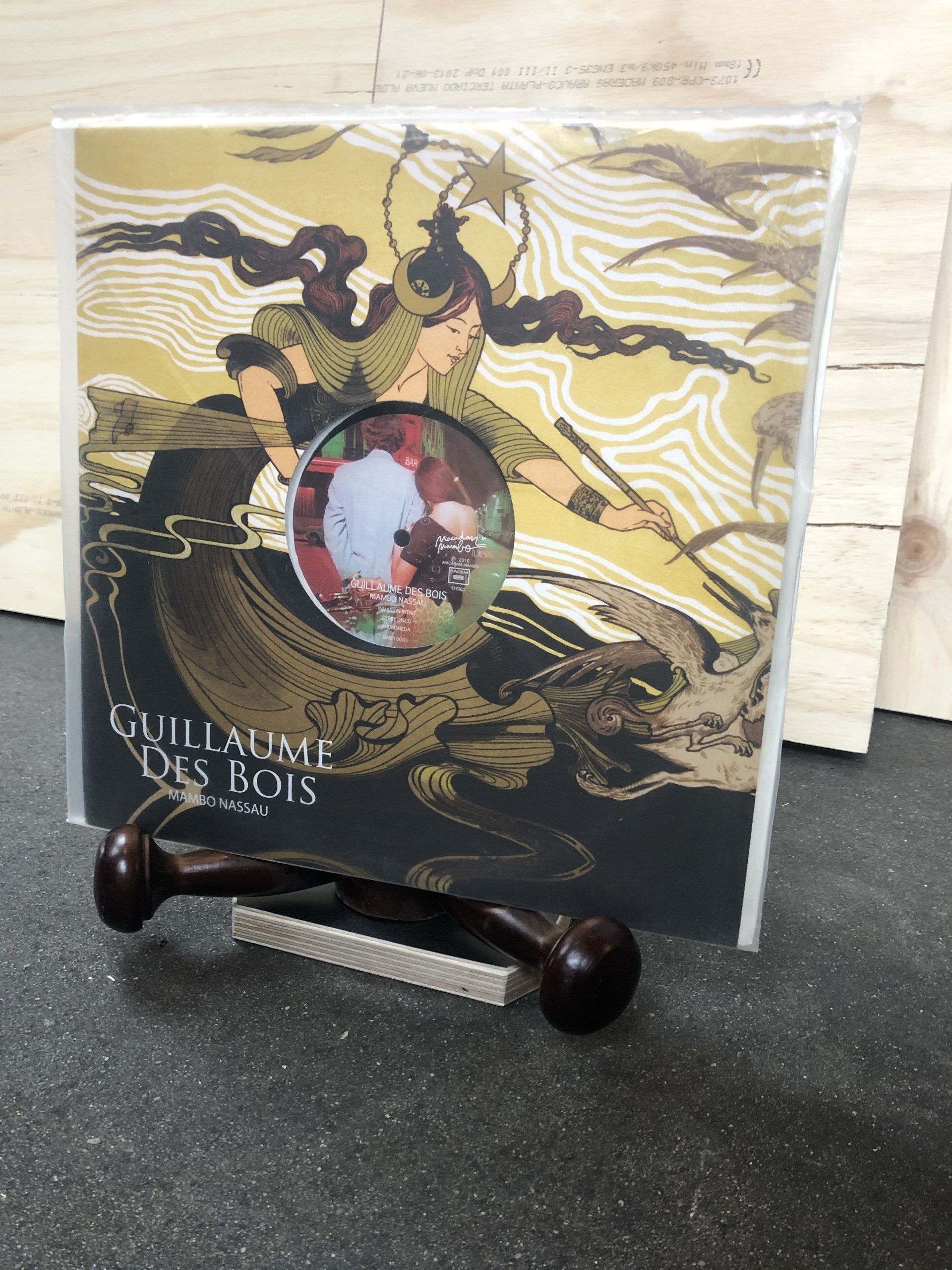 Albumhoes van Guillaume Des Bois met een gouden afbeelding van een persoon met een speer, die in een plastic hoesje zit.