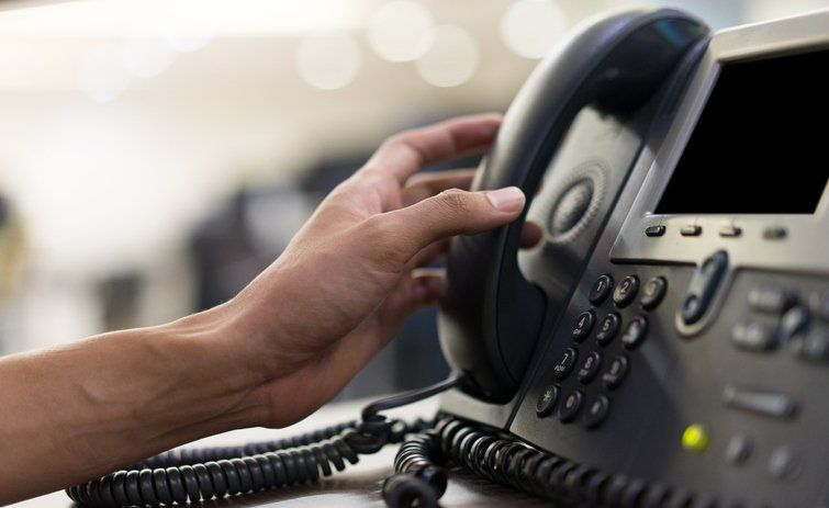 Hand Picking Up Phone to Make Call