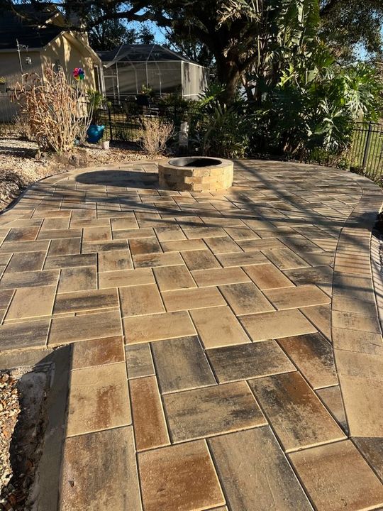 Stone staircase with decorative brick border ascends through a landscaped yard.