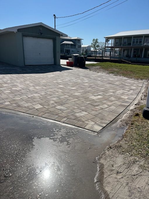 Pressure washer spraying water onto a brick patio, cleaning the surface.