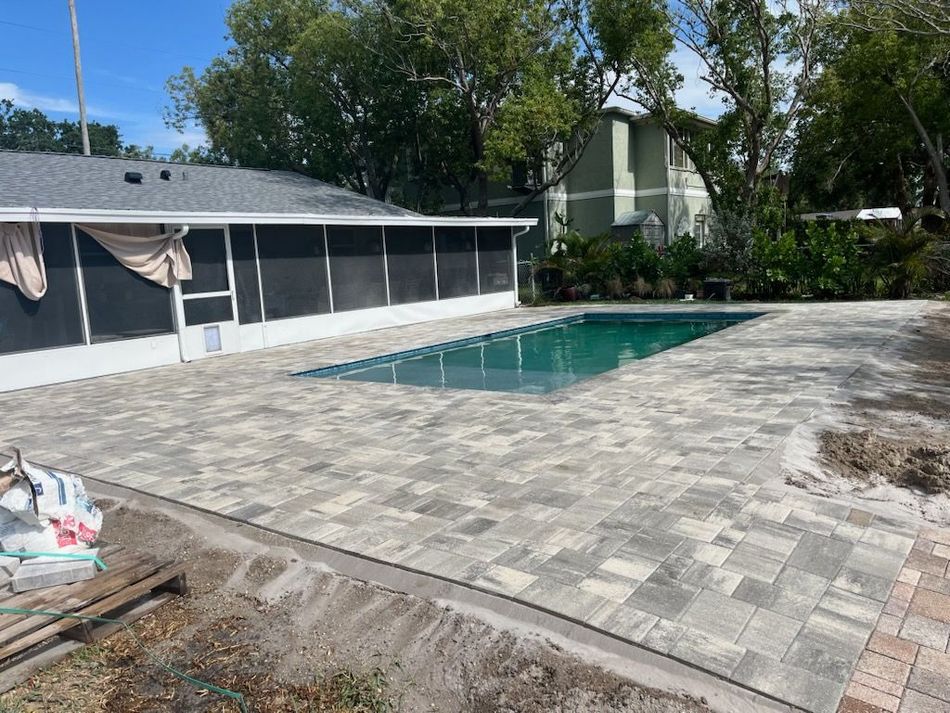 Person pressure washing a brick driveway.