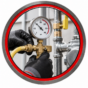 Technician adjusting a pressure gauge on industrial piping with a wrench