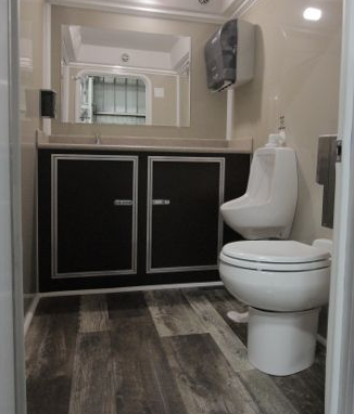 A bathroom with a toilet , sink and mirror.