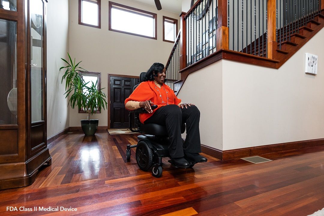 Joystick on a wheelchair armrest against a blue seat backdrop