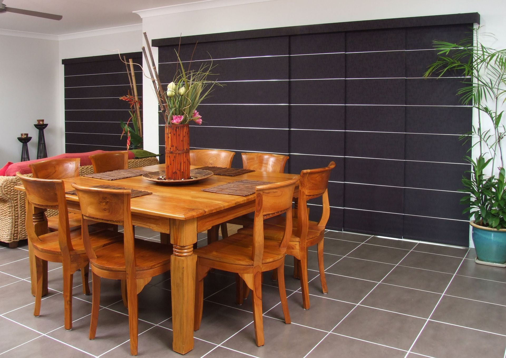 A Dining Room Table With a Vase of Flowers — Curtain Force NQ in Garbutt, QLD