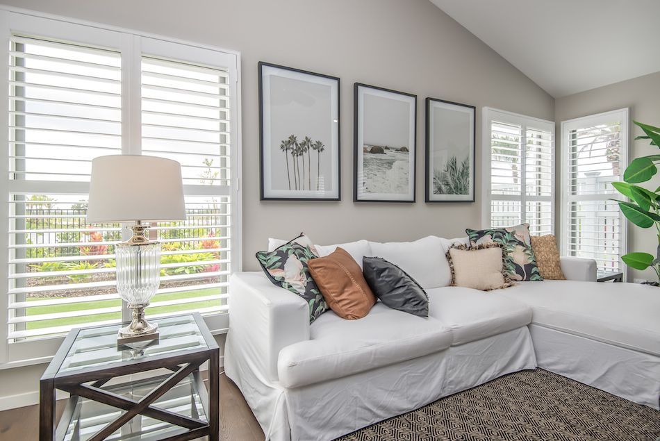 A Living Room With a White Couch and Shutters on the Window — Curtain Force NQ in Garbutt, QLD