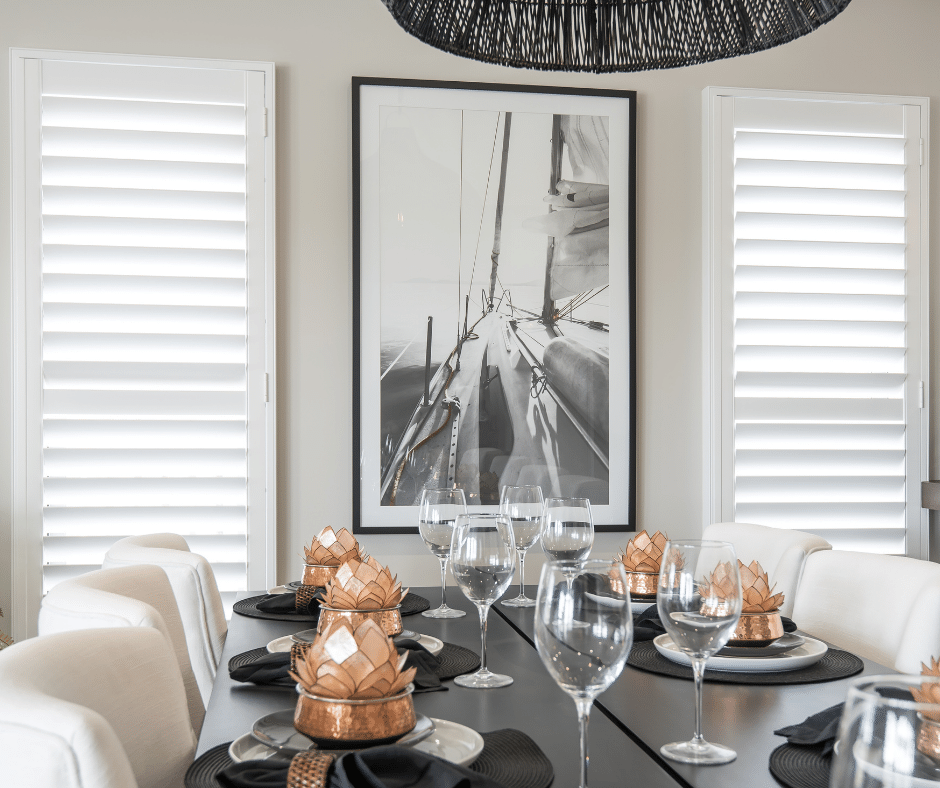 A Dining Room Table With Plates, Wine Glasses, and a Picture on the Wall — Curtain Force NQ in Garbutt, QLD