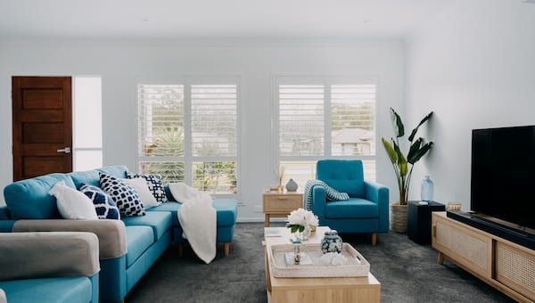 A Living Room With a Blue Couch, Two Blue Chairs, a Coffee Table and a Television — Curtain Force NQ in Garbutt, QLD