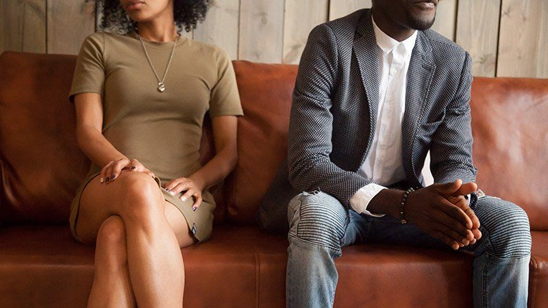 man and woman sit on couch