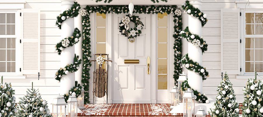 A white house decorated for christmas with a wreath on the door.