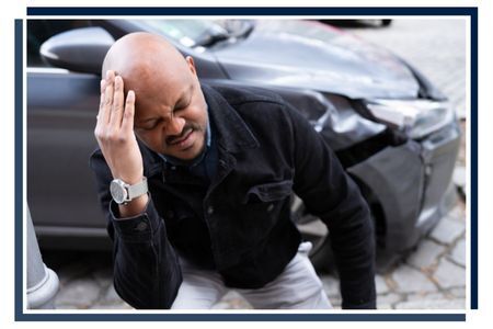 a man holding his head after a car accident