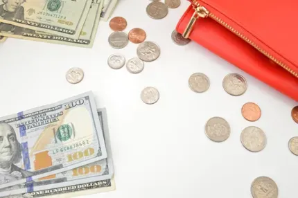 hundred dollar bills, twenty dollar bills, and coins scattered on a table
