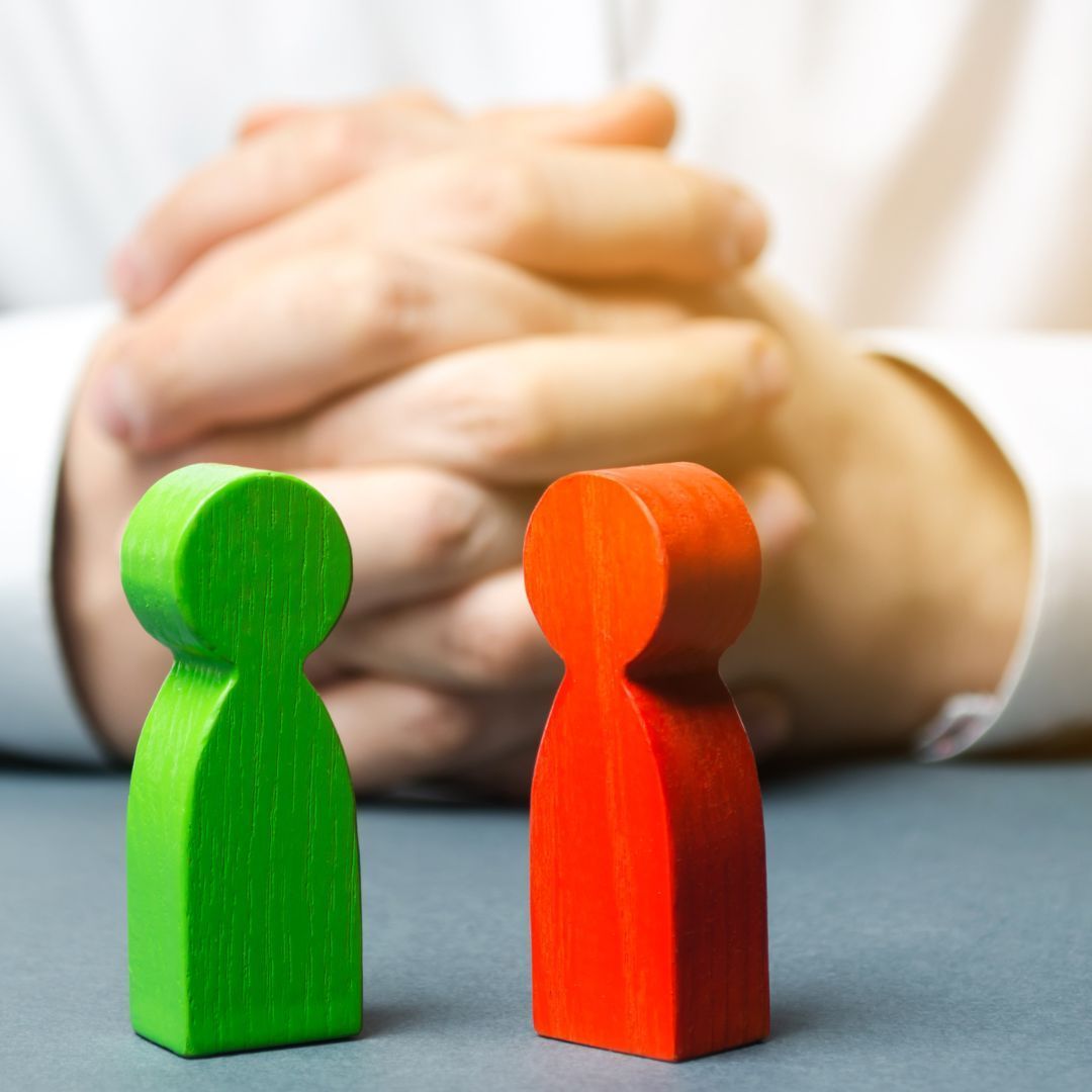 Two wooden figures are sitting next to each other on a table