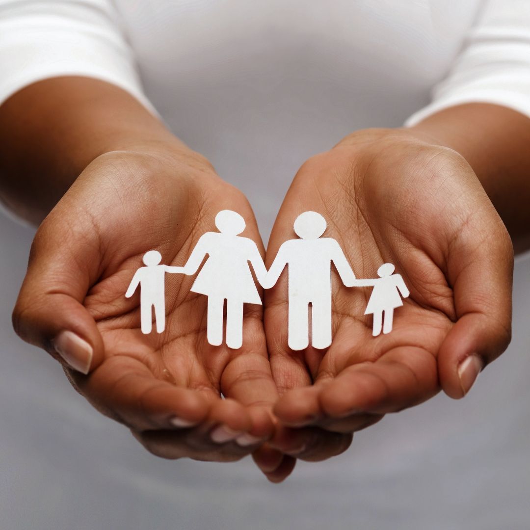 A person is holding a paper cut out of a family