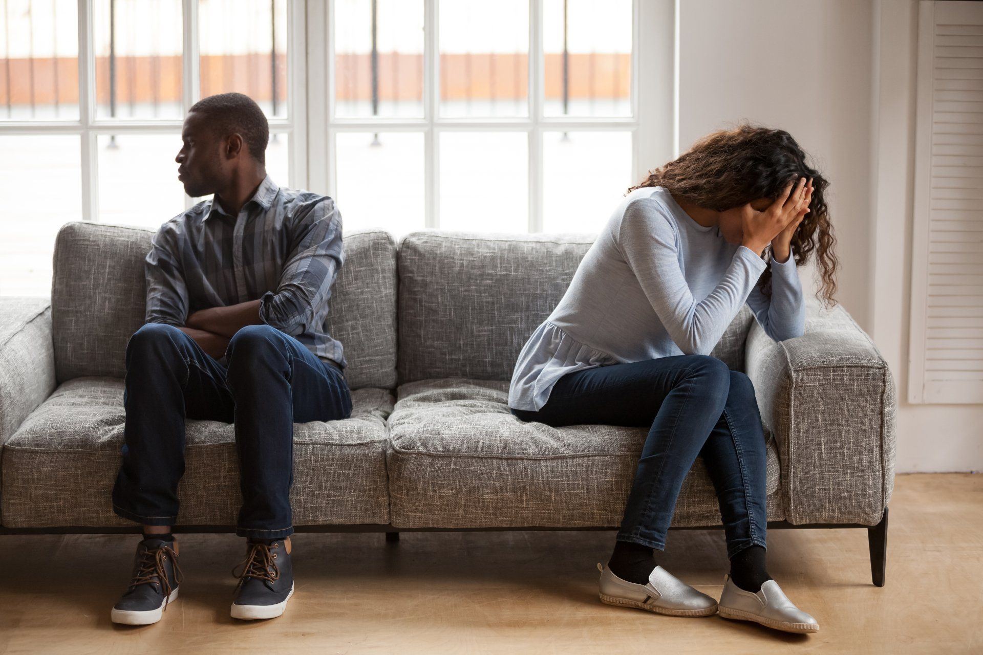 A man and a woman are sitting on a couch looking at each other.