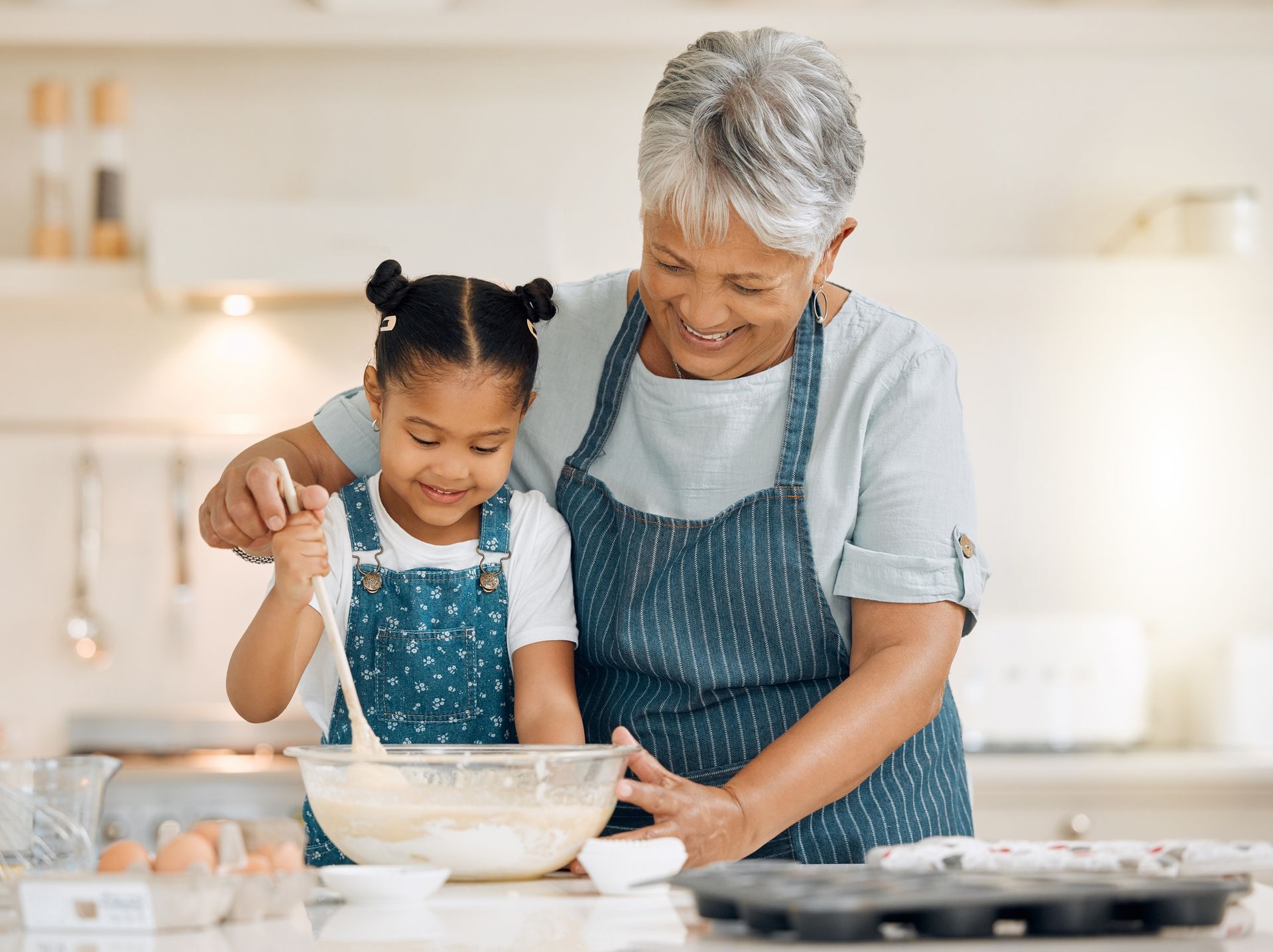 a grandmother and granddaughter baking together