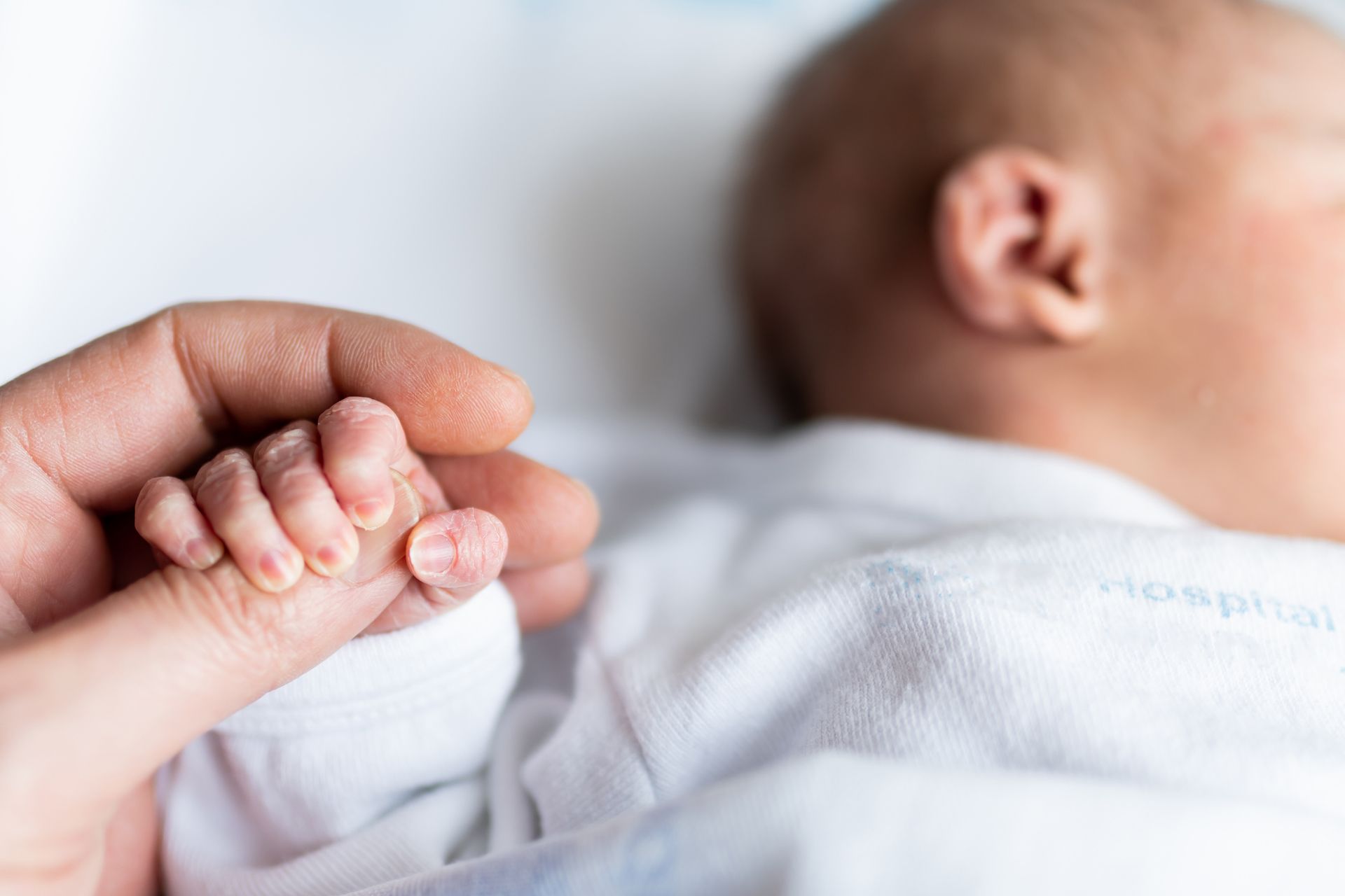 a baby holding dad's hand