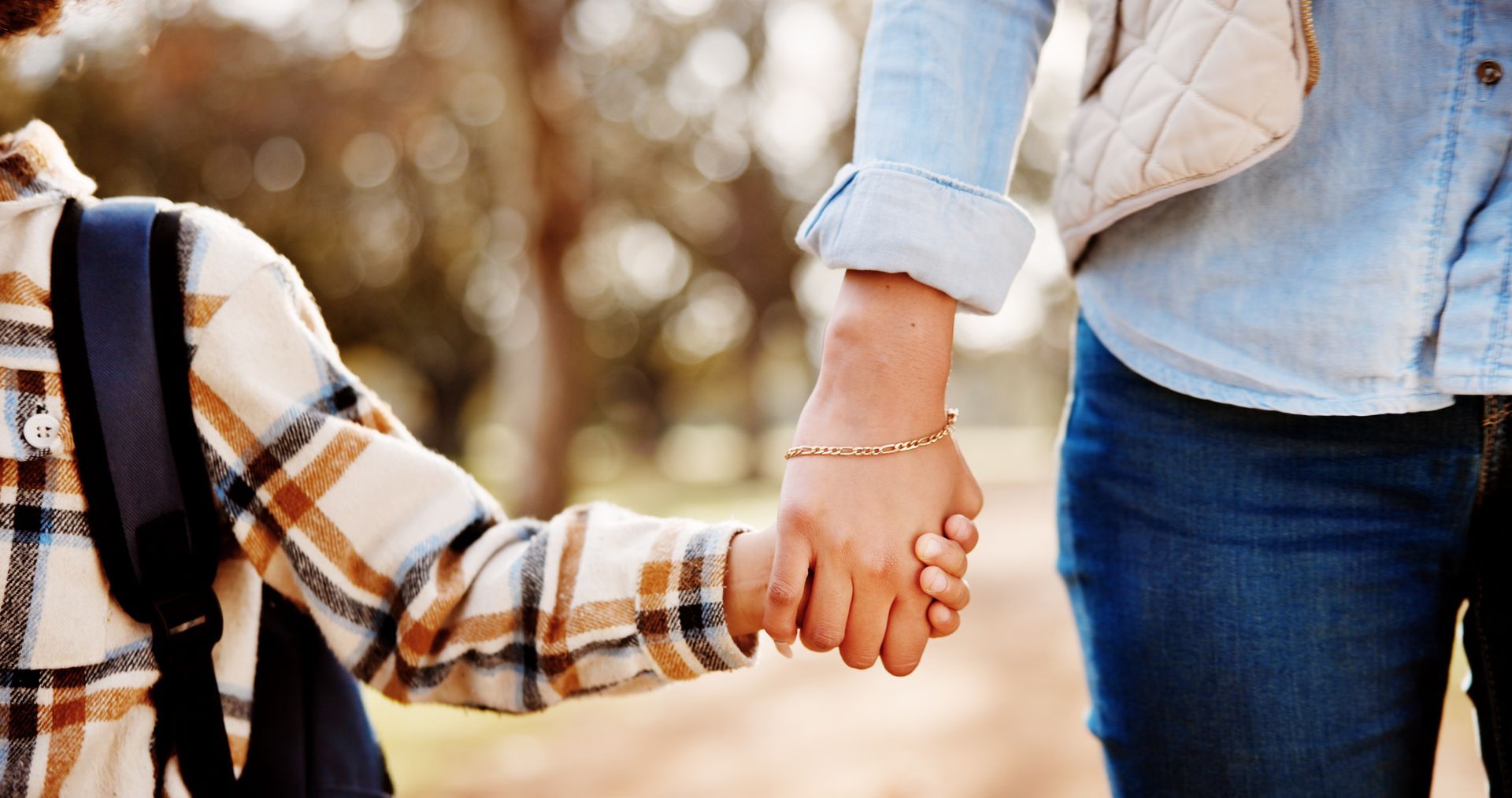 a parent holding their child's hand
