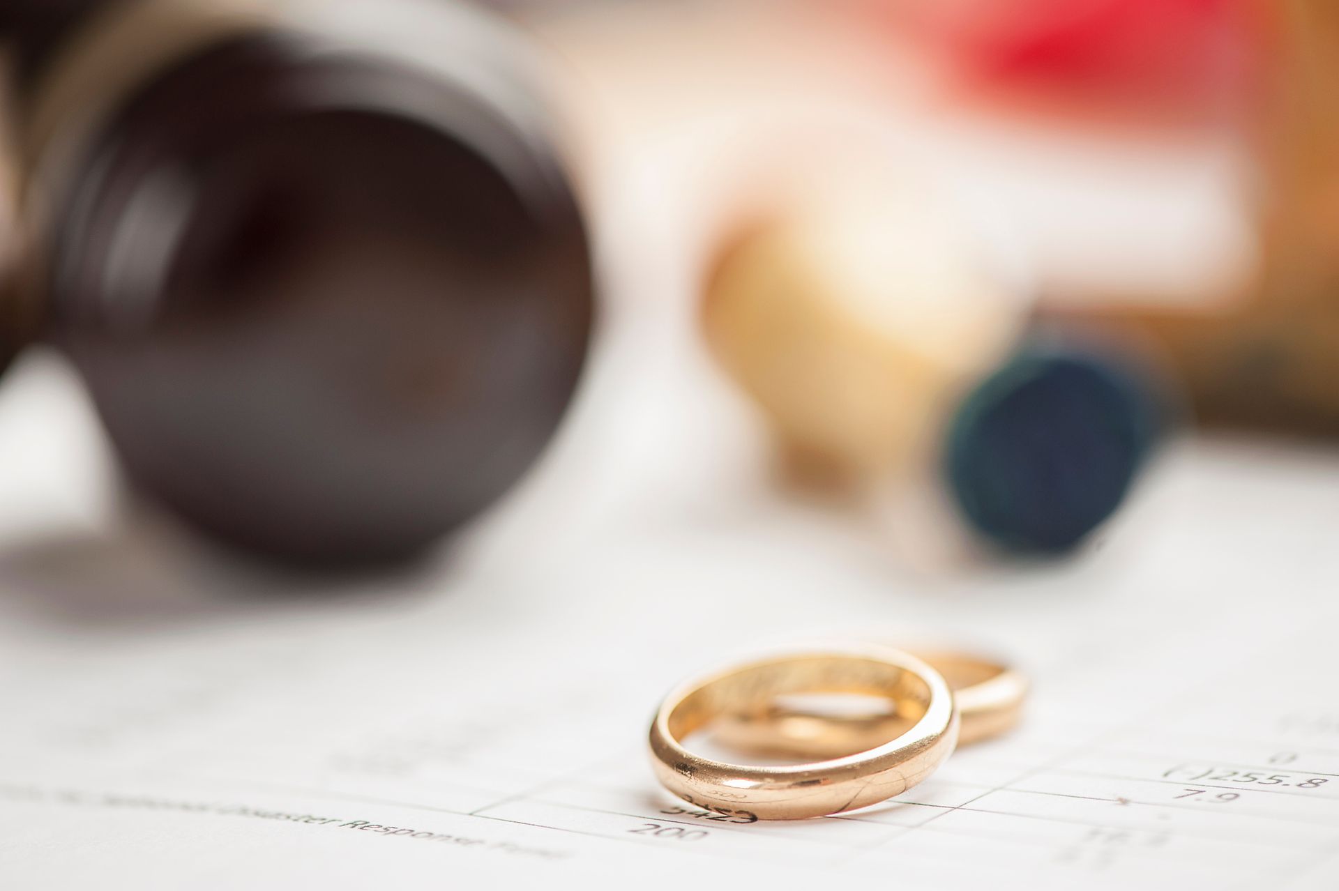 gold wedding rings on top of paperwork