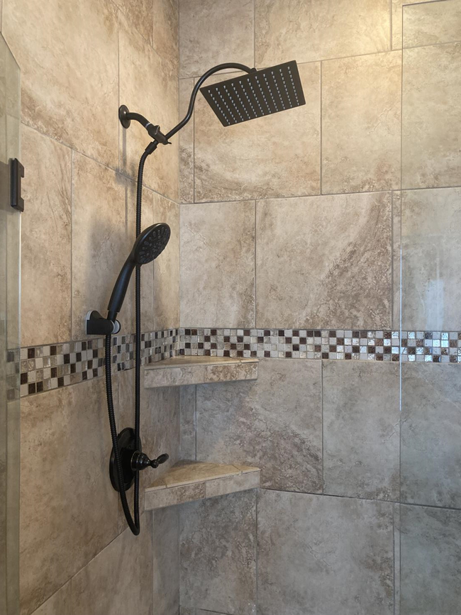 Exterior water spigot installed on a brick wall with exposed plumbing in a small ditch.