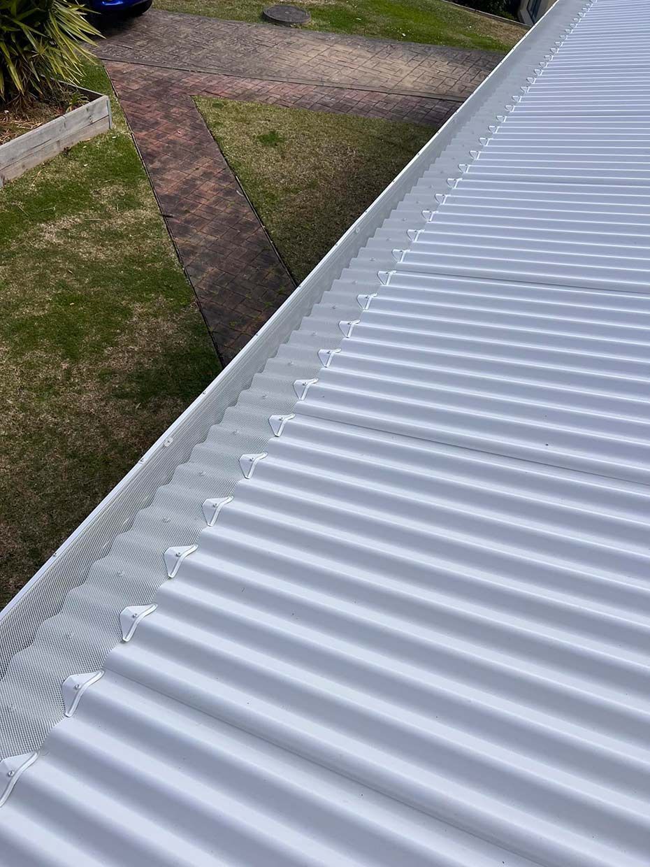A Close Up of a White Corrugated Metal Roof With a Gutter — Gutterworx in Wamberal, NSW