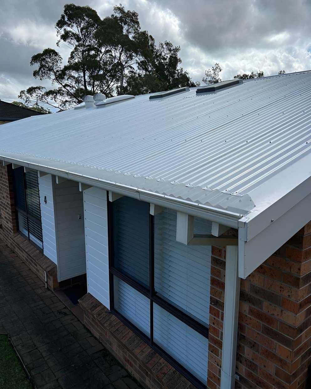 A House With a White Roof and a Brick Wall — Gutterworx in Toukley, NSW