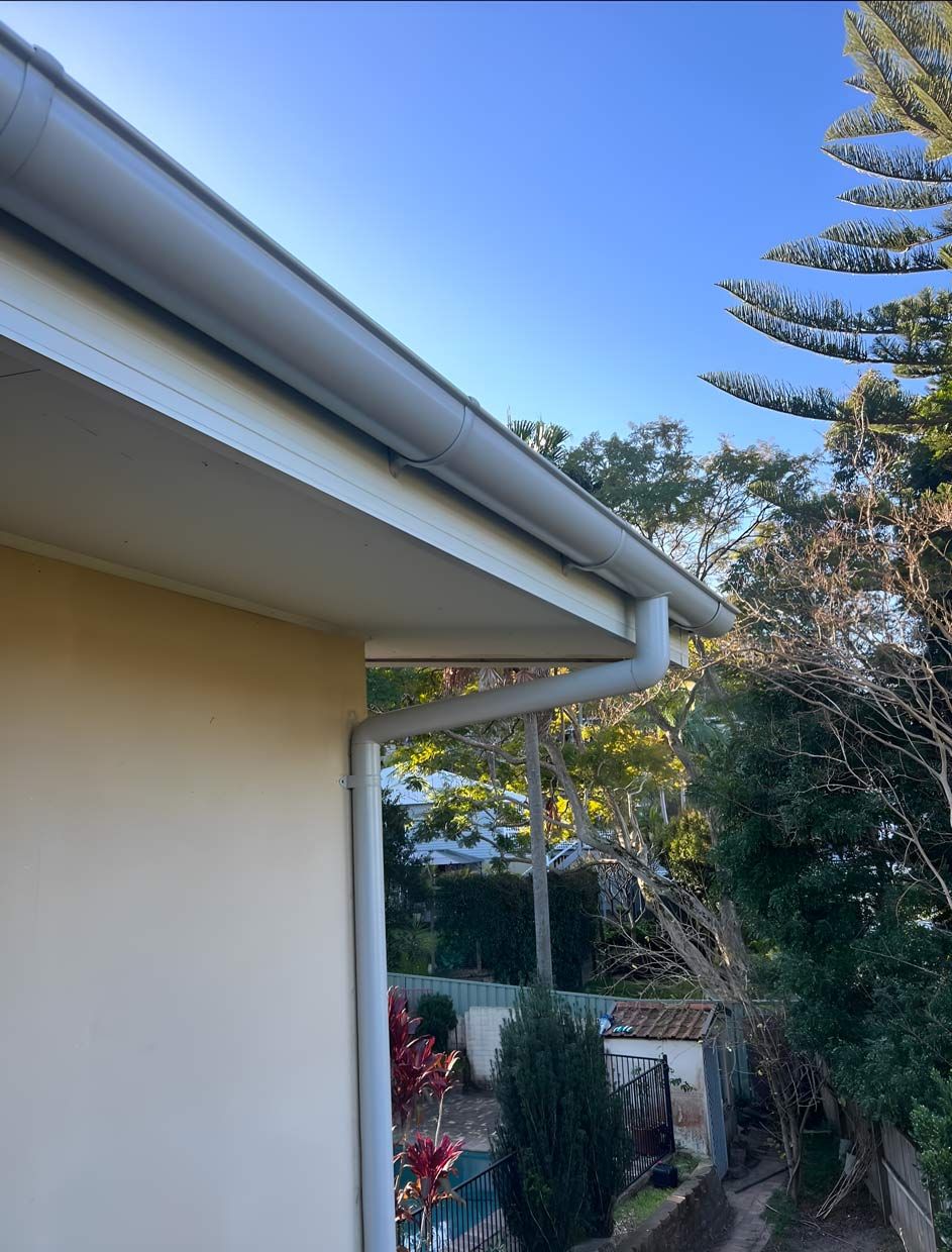A White Gutter on the Side of a House With Trees in the Background — Gutterworx in Wamberal, NSW