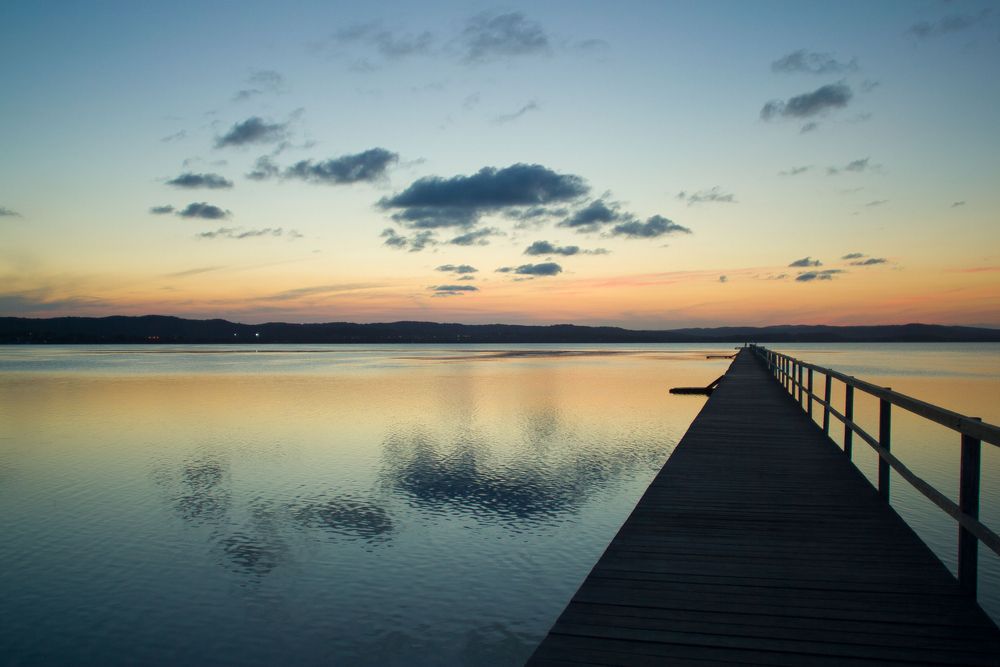 Sunset Over Calm Water With a Wooden Pier — Gutterworx in Tumbi Umbi, NSW