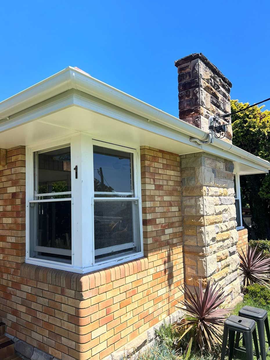 A Brick House With a White Window and a Chimney — Gutterworx in Central Coast, NSW