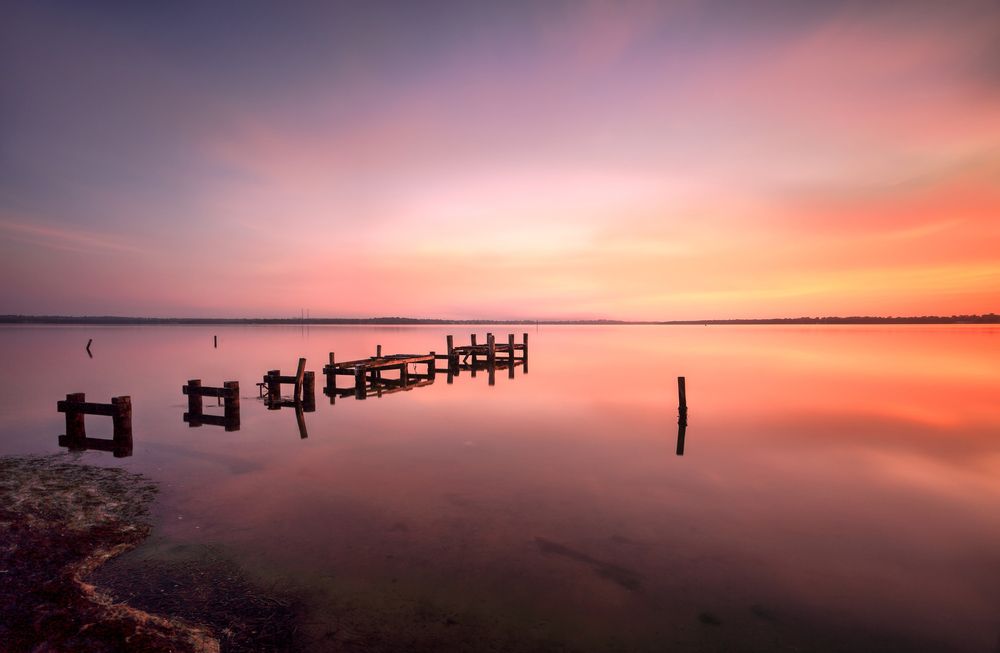 A Sunset Over a Lake With a Dock in the Water — Gutterworx in Gorokan, NSW