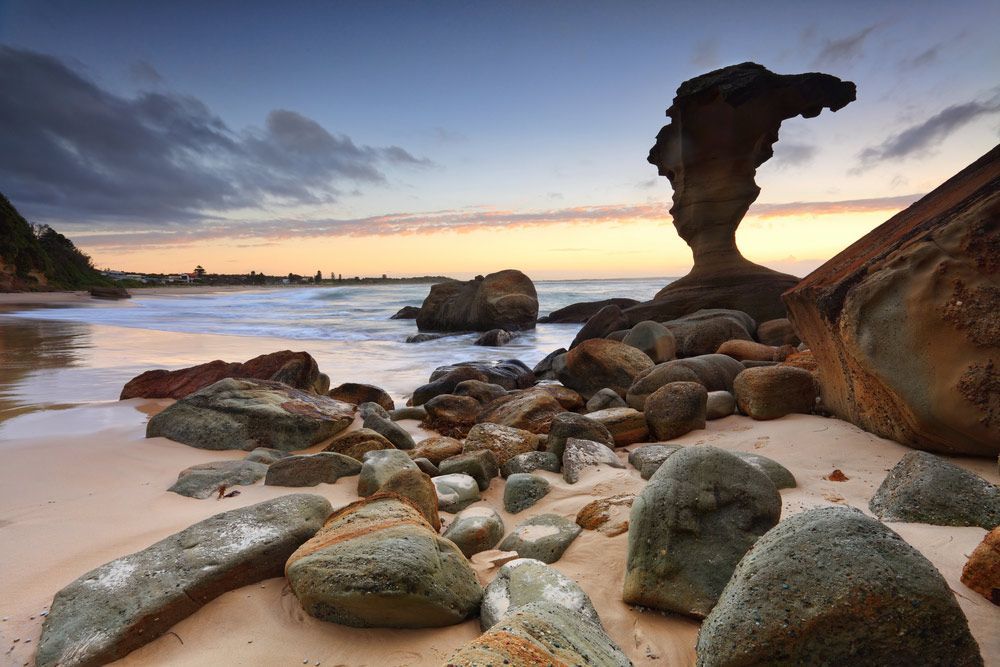 A Rock Formation on a Beach With a Sunset in the Background — Gutterworx in Noraville, NSW