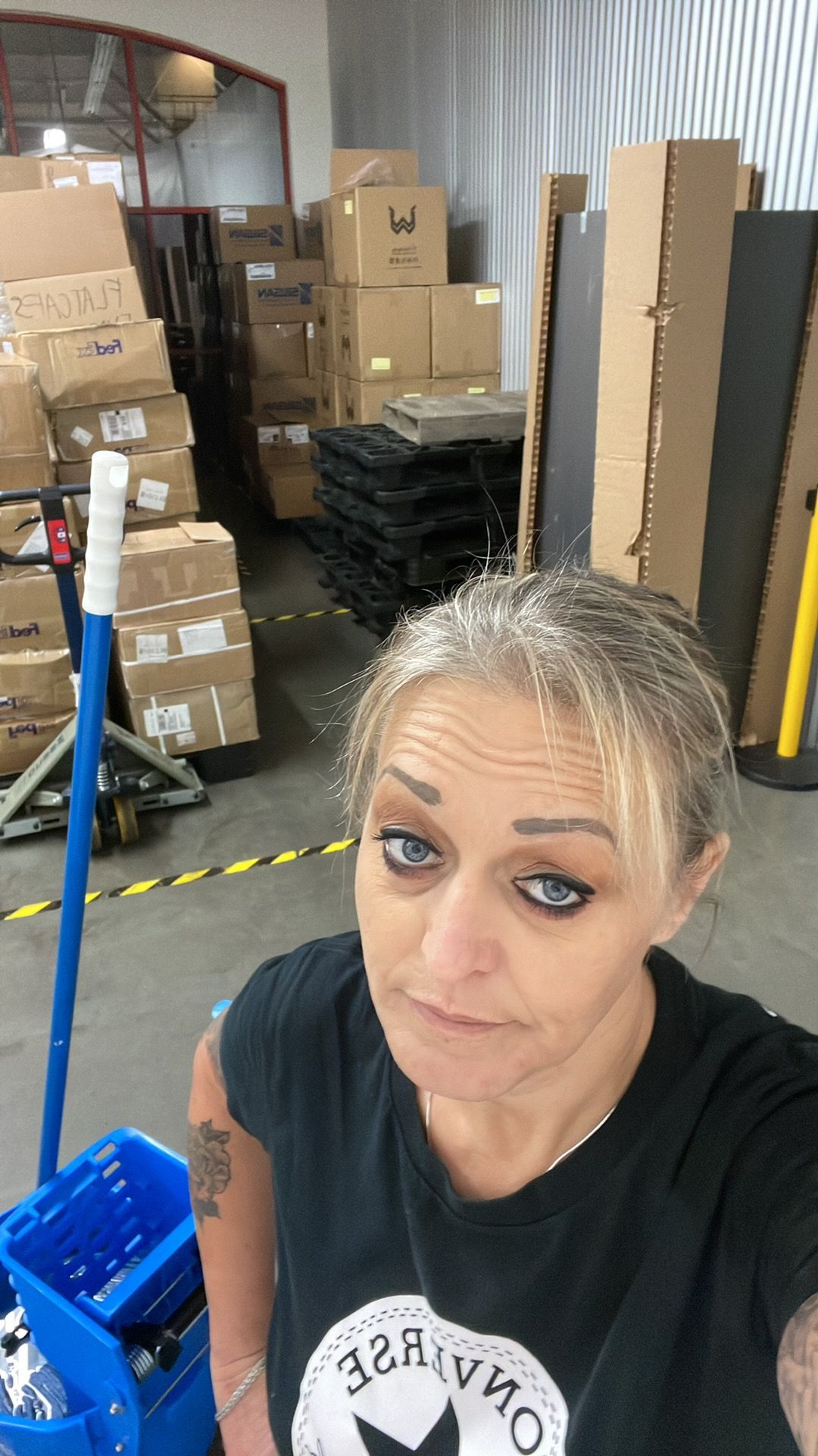A woman is taking a selfie in a warehouse.