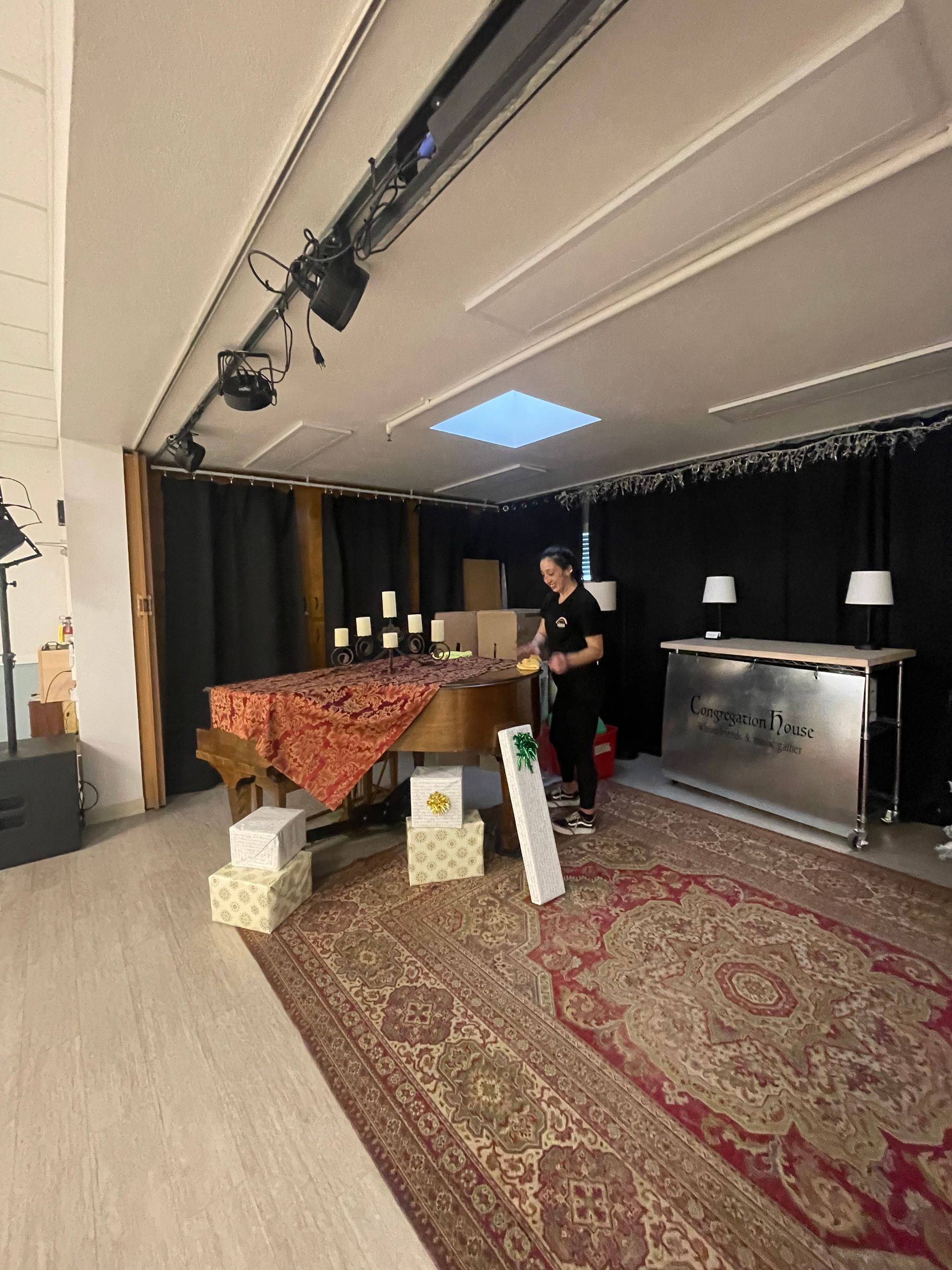 A man is standing in a room with a piano and boxes