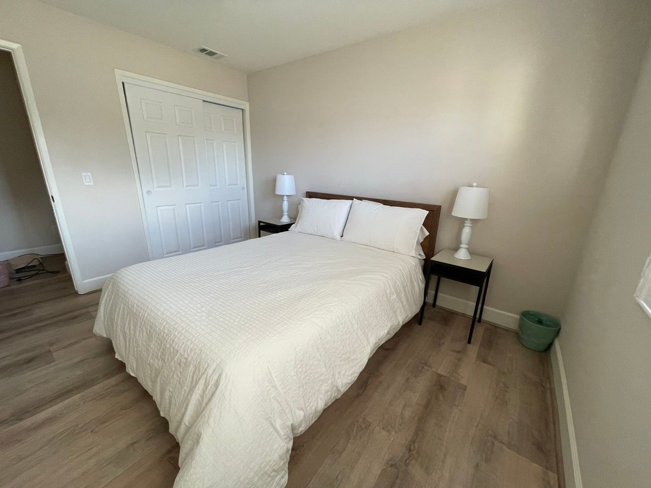 A bedroom with a bed and two lamps