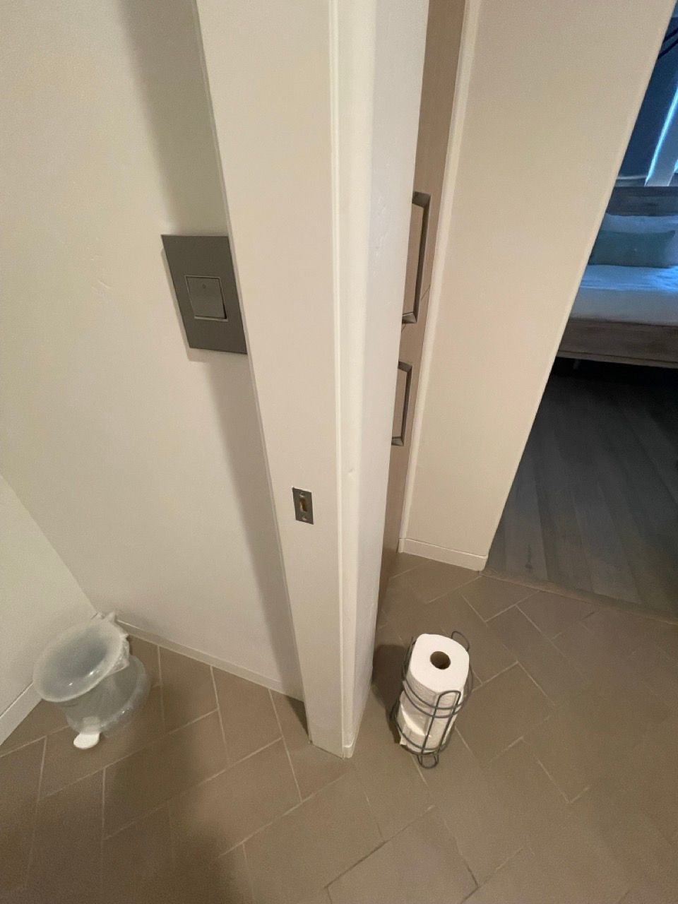 A roll of toilet paper is sitting on the floor next to a door.