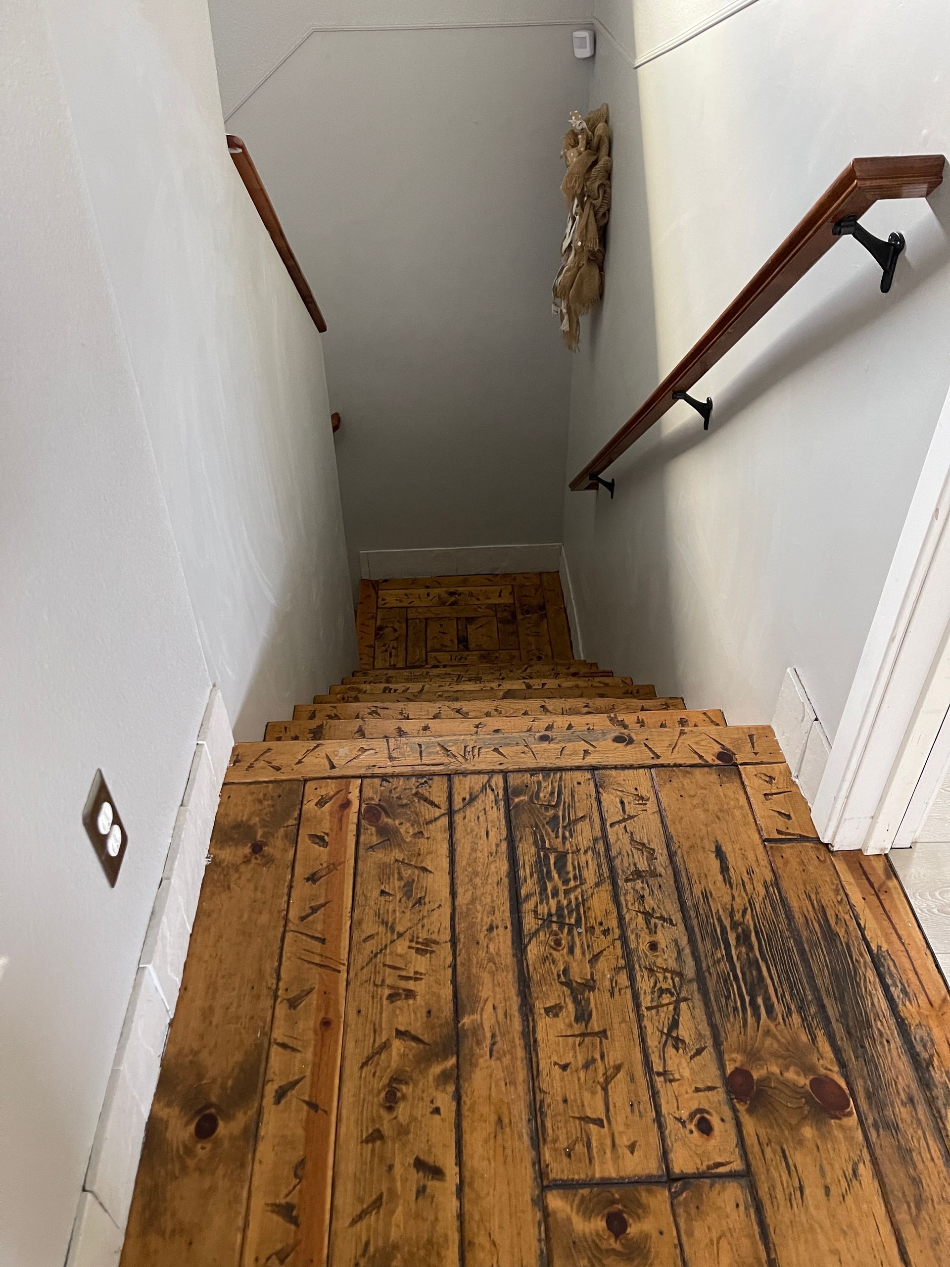 A staircase with a wooden floor and a hand rail