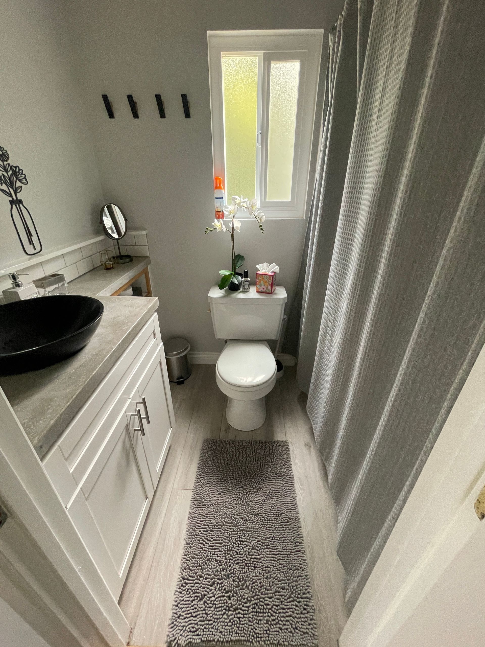 A bathroom with a toilet , sink , and shower curtain.