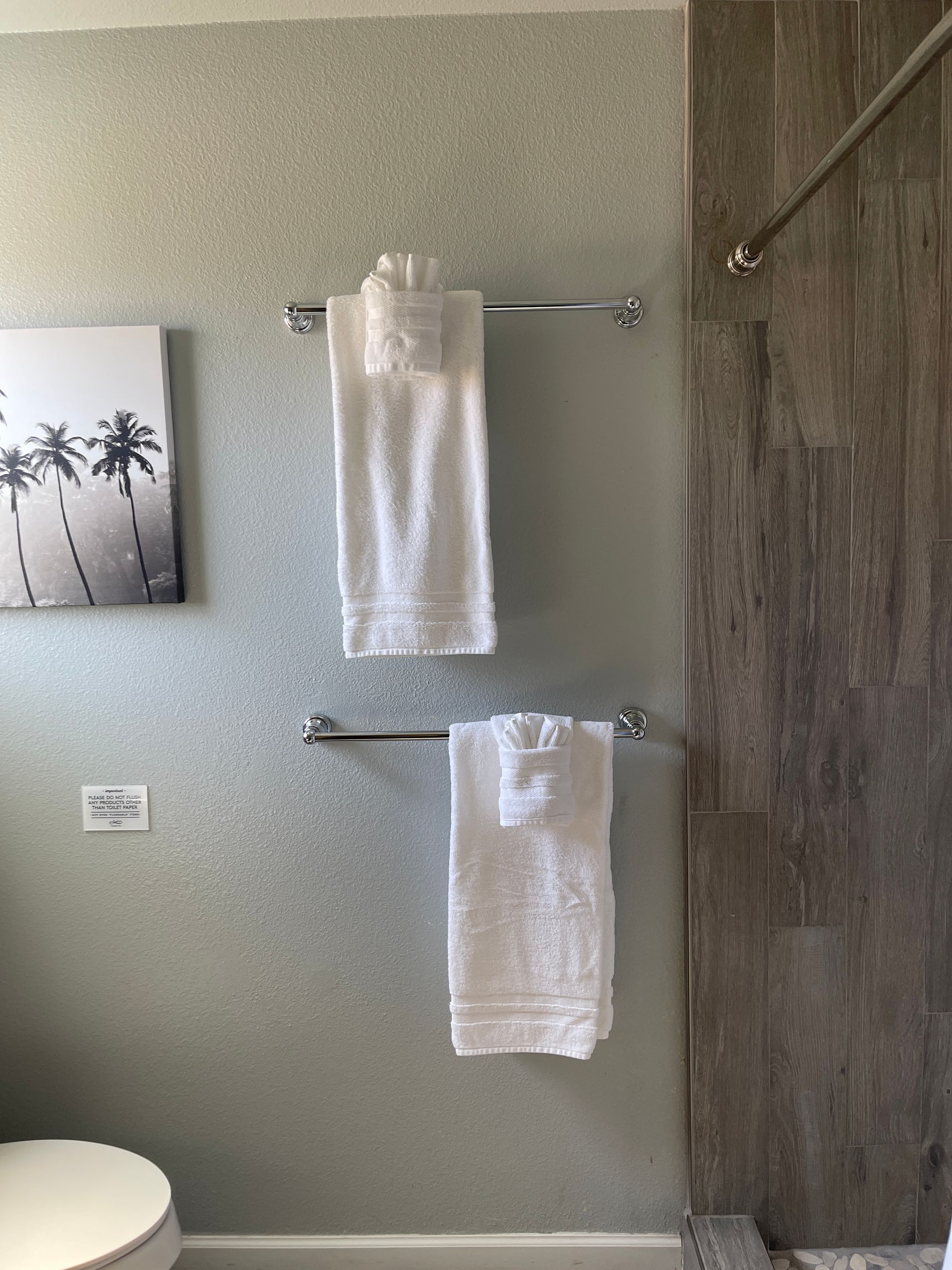 Two towels are hanging on a towel rack in a bathroom next to a toilet.