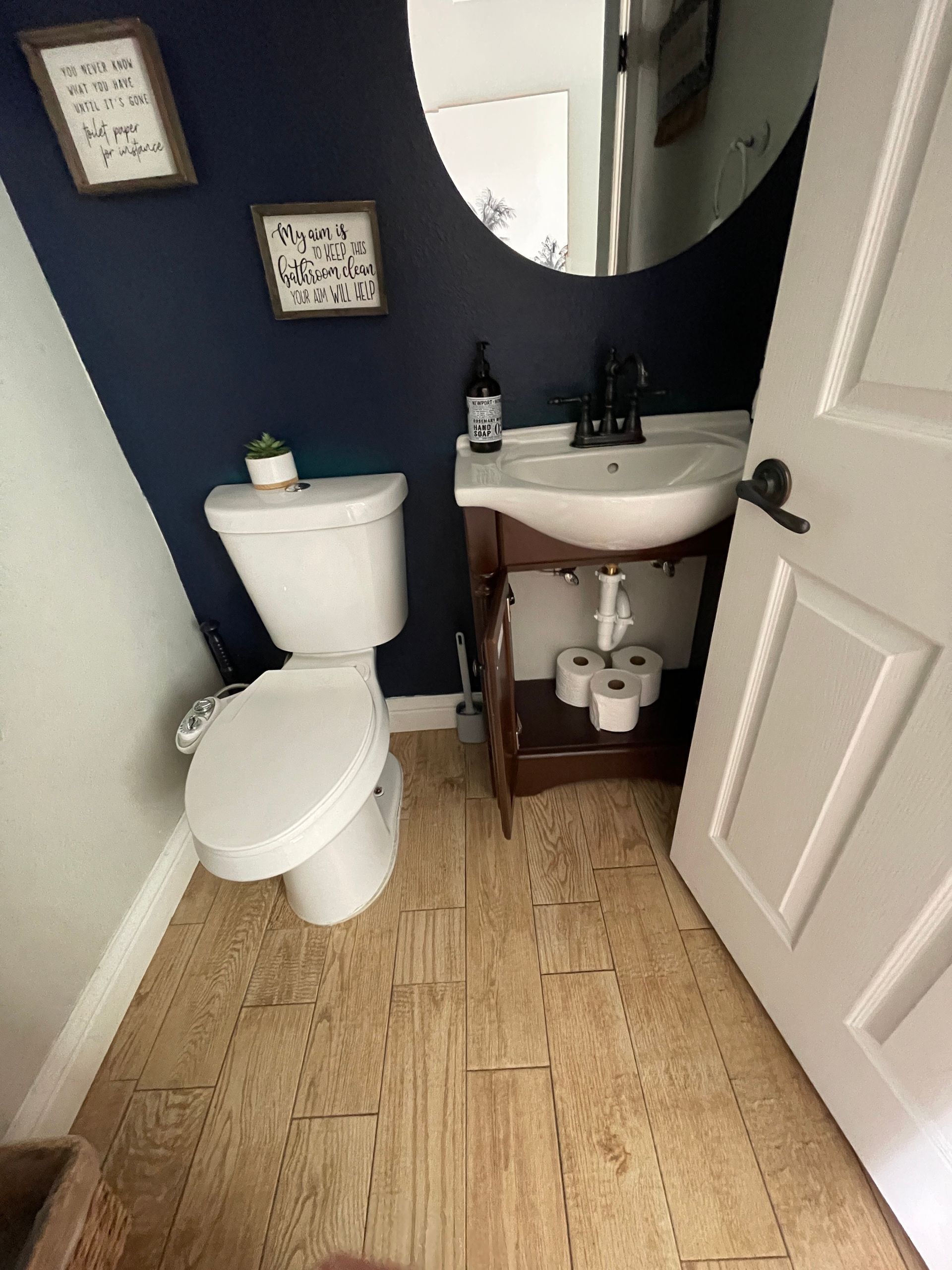 A bathroom with a toilet a sink and a mirror
