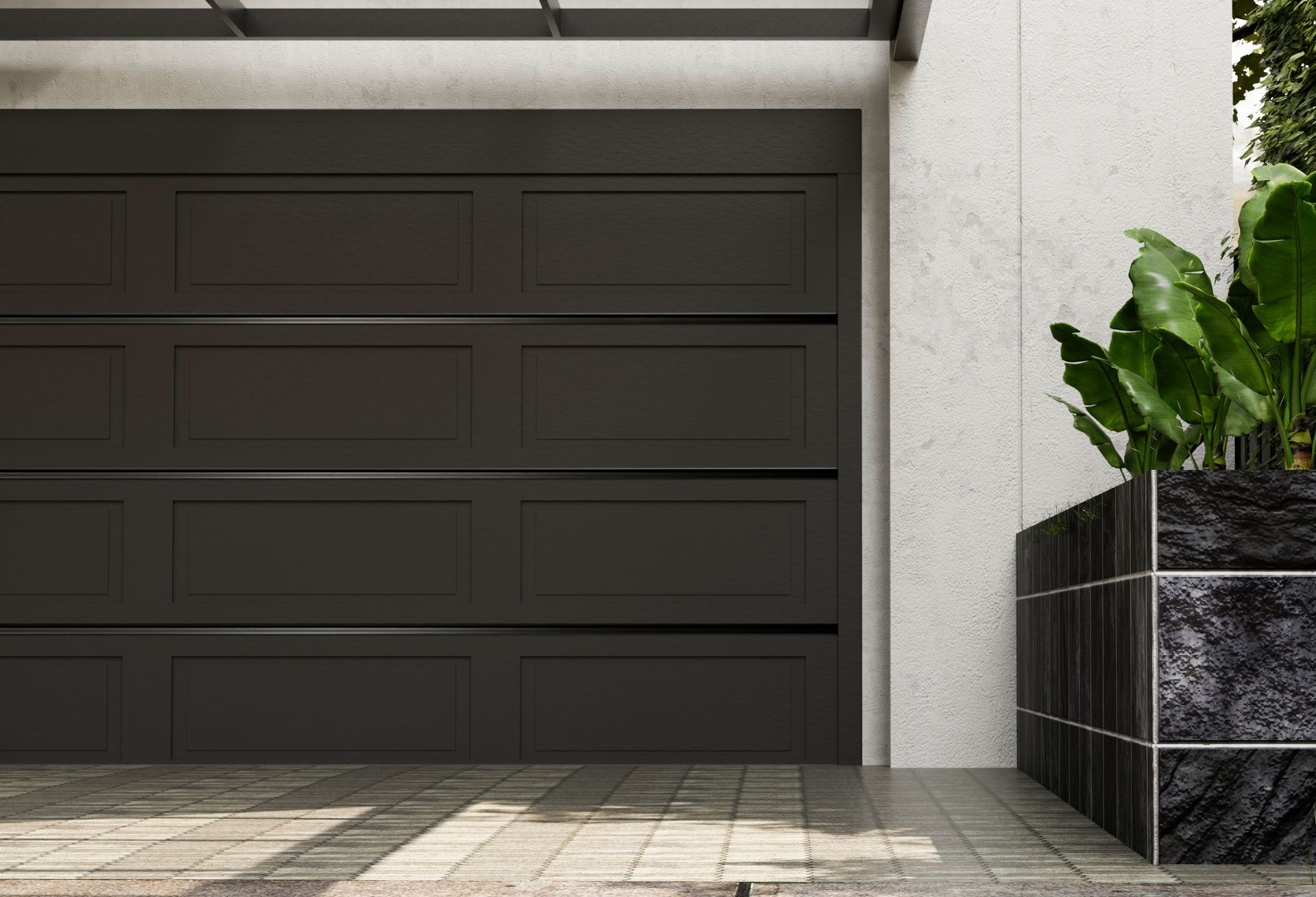 front view of a black metal garage door in the foreground with plants on one side