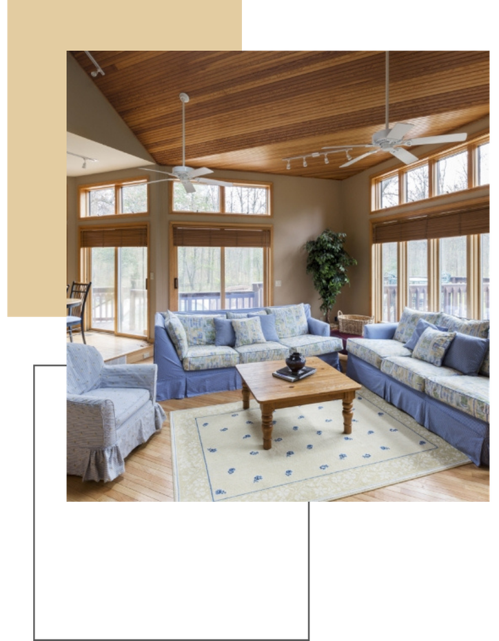 Bright living room with blue sofas, wooden coffee table, and large windows under a wood ceiling