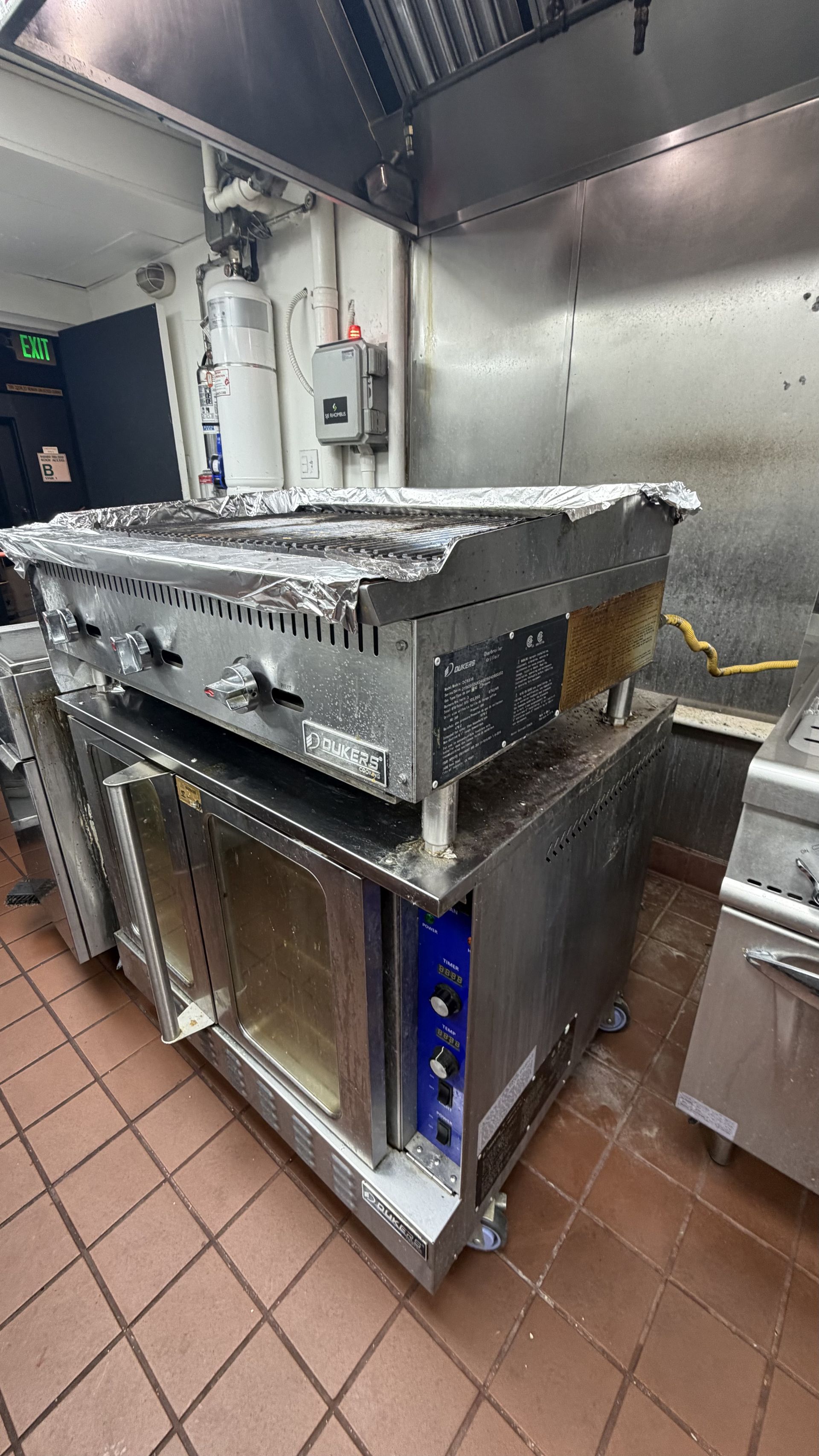Industrial kitchen with a large stainless steel countertop and undercounter equipment on a tiled floor