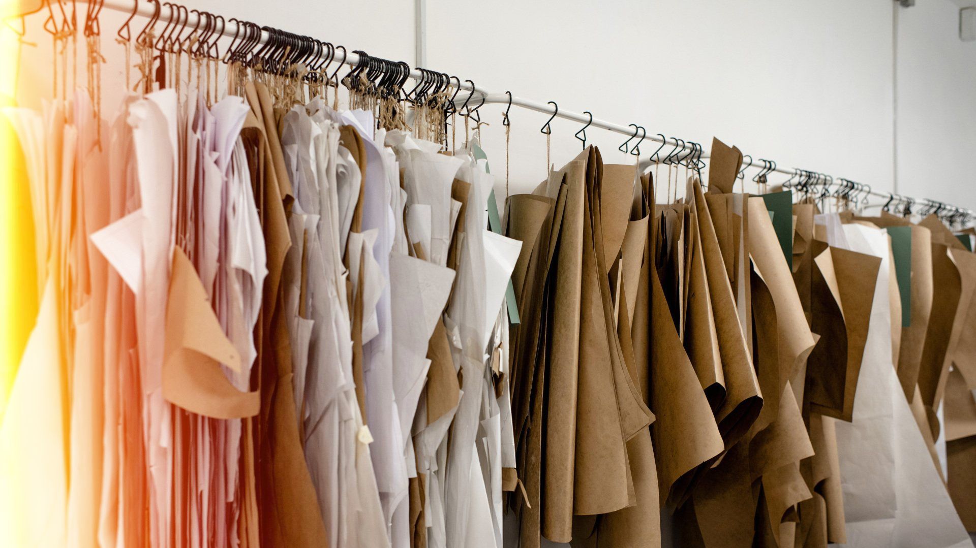 a row of clothes hanging on a rack in a clothing factory .