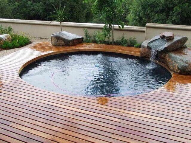 Swimming Pool With Wooden Flooring — Pool Installation in Macquarie Fields, NSW
