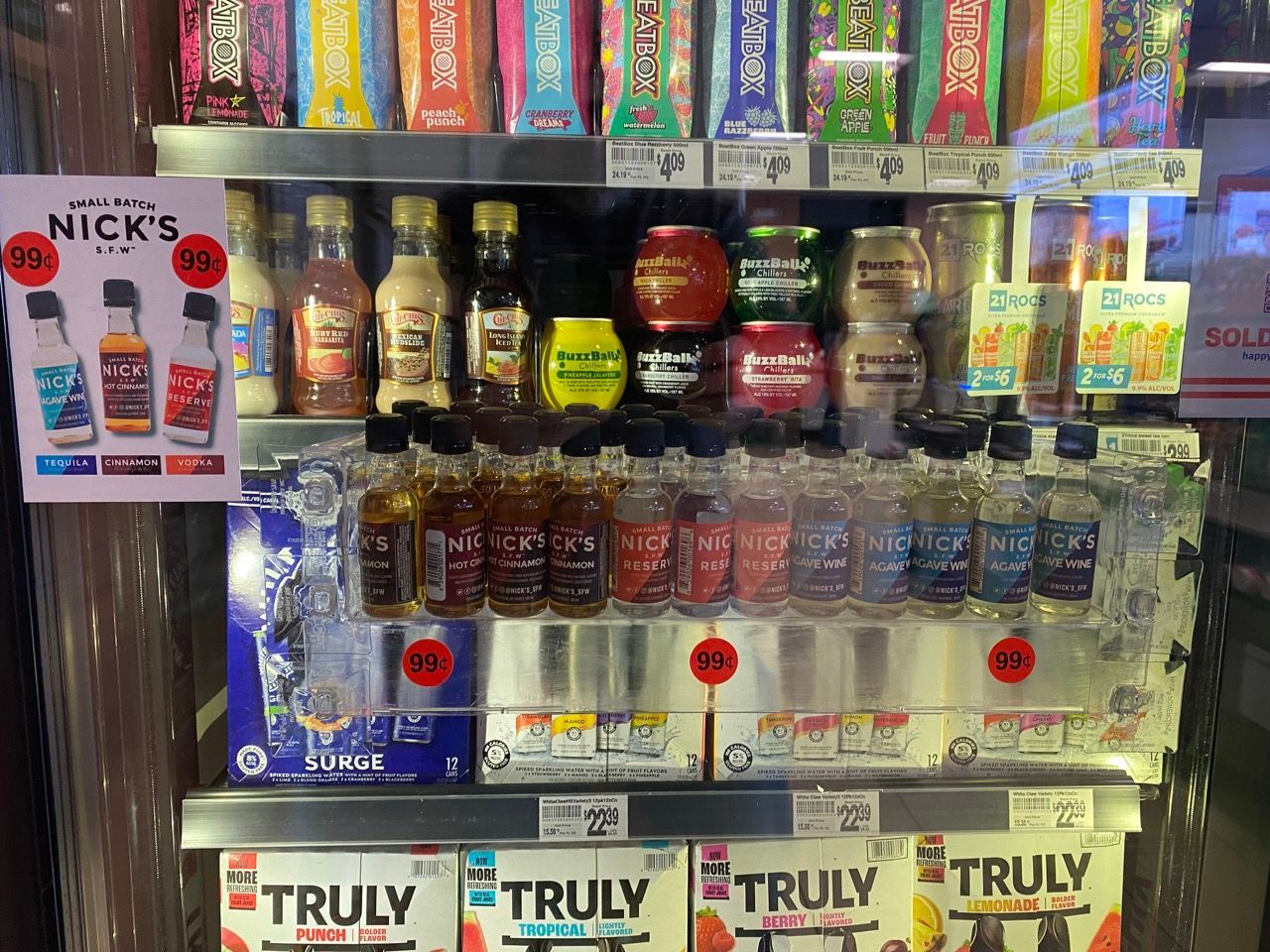 A shelf filled with bottles of alcohol and a sign that says truly on it.