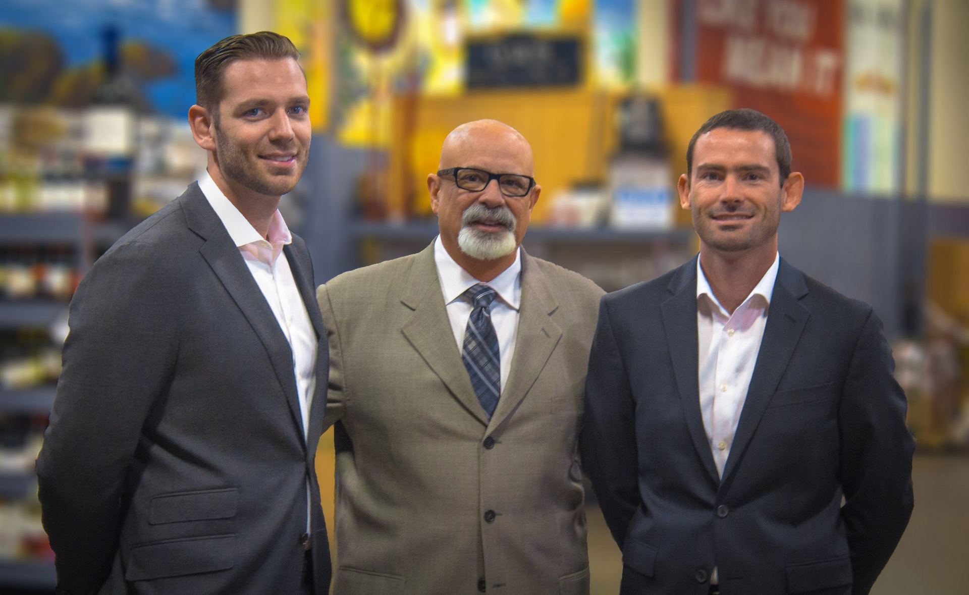 Three men in suits and ties are posing for a picture.