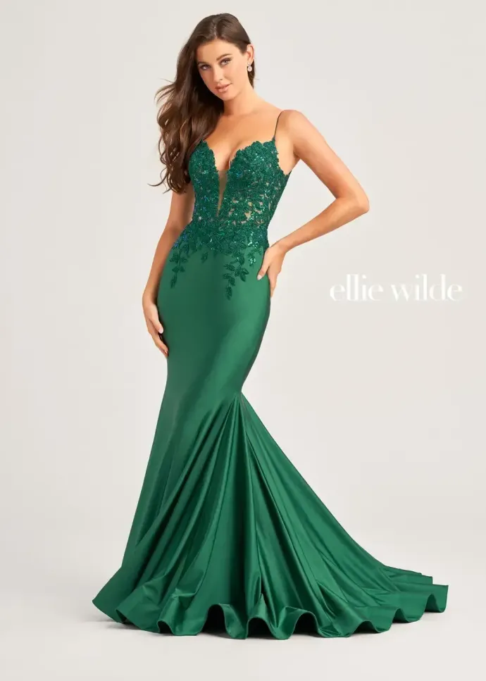 A woman is wearing a green dress with a plunging neckline.