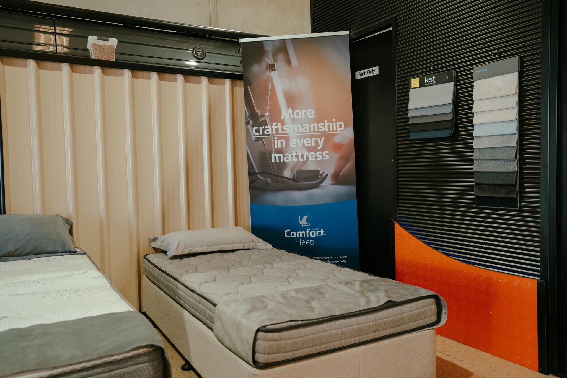 Two Beds in a Showroom With a Banner Reading — Coastal Mattress' Direct in Brisbane, QLD