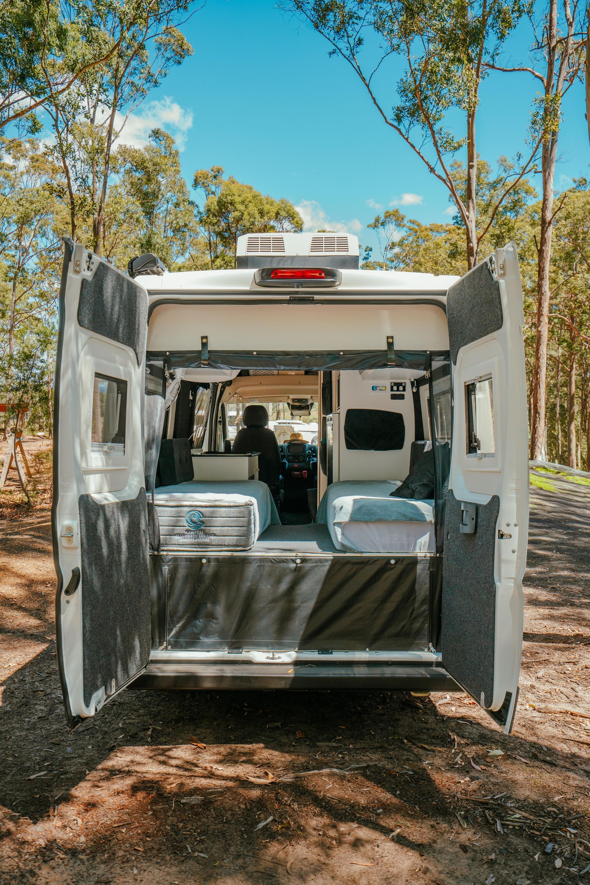 Back of a White Camper Van With Open Doors, Revealing Interior — Coastal Mattress' Direct in Brisbane, QLD