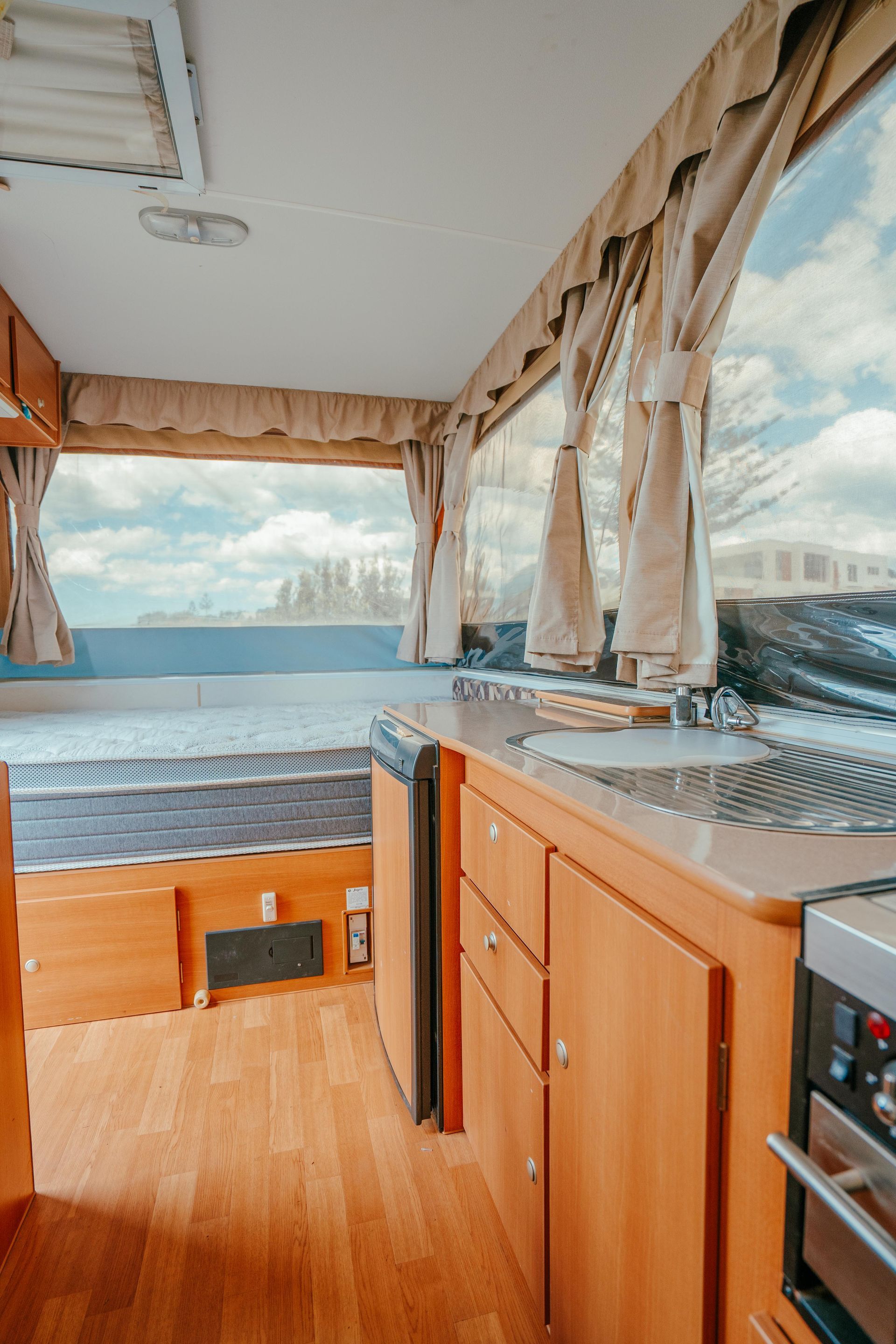 Interior of a Camper, Featuring Kitchen, Bed, and Window — Coastal Mattress' Direct in Brisbane, QLD